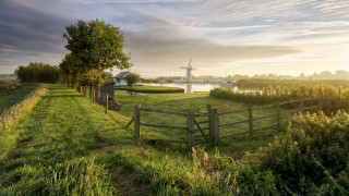 Grassy fence windmill river landscape - a grassy field free wallpaper for desktop
