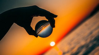 Sunset person holding ball optical - the sun setting free wallpaper