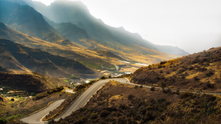 Mountain road town lake sunset - a mountain range in the distance free wallpaper