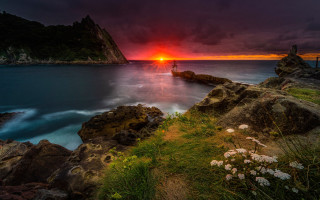 Sunset rocky beach boat mountain - the water and a mountain in the background free wallpaper