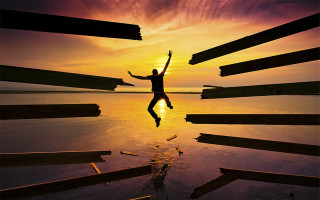 Man jumping over water sunset - surreal photography free wallpaper for desktop