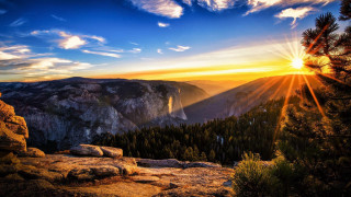 Sunset mountain trees sunlight clouds - a beautiful sunset over a mountain range free wallpaper