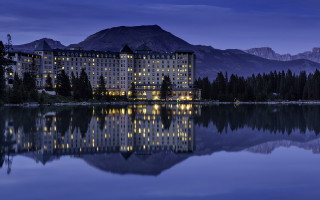 Large building lake mountains night - a large building free wallpaper
