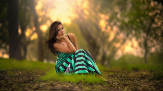 Woman forest sitting blurry green - the ground in a forest free wallpaper