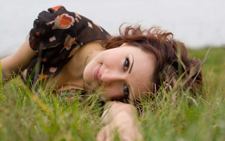 Woman laying in grass blowing - anna haifisch free wallpaper