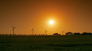 Grass turbines sunset mountains sky - the sun in the distance free wallpaper
