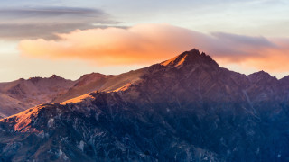 Mountain range plane sunset clouds - the background and a plane in the foreground free wallpaper