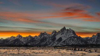 Snowy field mountains sunset red - a mountain range in the background free wallpaper
