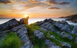 Sunset cliff grass rocks water - a sunset over a rocky cliff free wallpaper