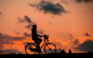 Sunset bicycle silhouette clouds cityscape - the background and a person free wallpaper