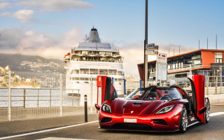 Red sports car cruise ship - a boat in the background free wallpaper for desktop