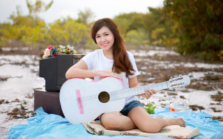 Woman sitting guitar smiling beach - a guitar free wallpaper