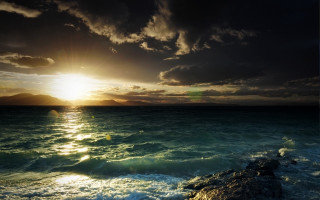 Sunset ocean rocky shore mountains 4 - a bright sun free wallpaper
