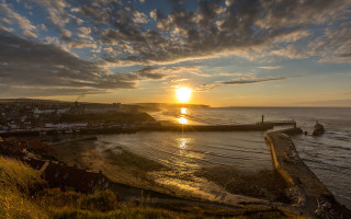 Sunset beach pier houses water - a sunset over a beach free wallpaper