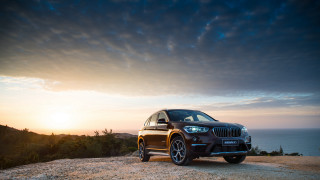 Black bmw suv ocean sunset - a rocky hill free wallpaper
