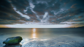 Rock beach sunset cloudy sky 4 - a sandy beach under a cloudy sky free wallpaper