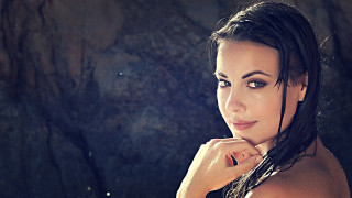 Woman wet hair rock wall - head and shoulders portrait free wallpaper