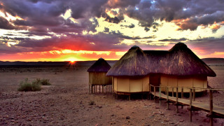 Sunset desert huts bridge cloudy - a sunset over a desert free wallpaper