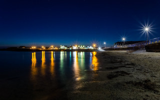 Night beach pier lights reflection - a photo free wallpaper for desktop