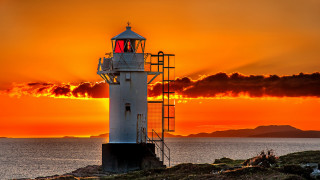 Lighthouse rocky shore sunset clouds 15 - radiant light free wallpaper for desktop