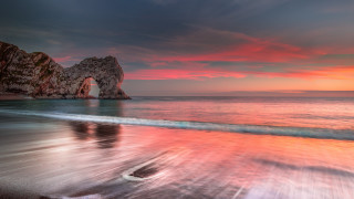 Beach rock formation sunset pink 2 - the water and a sunset in the background free wallpaper