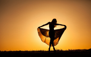 Woman sunset field sheer dress - the sun setting behind her free wallpaper