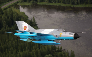 Fighter jet over forest river - a forest in the foreground free wallpaper