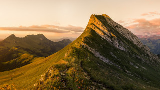 Mountain grassy slope sunset pink - a grassy field below free wallpaper