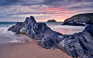 Rocky beach sunset water formation - a sunset in the background and a body of water free wallpaper