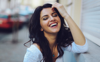 Smiling woman leaning wall jewelry - elke vogelsang free wallpaper