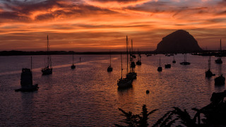 Sunset boats mountain red sky - the water and a mountain in the background free wallpaper