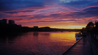Sunset water boat city horizon - the water and a city in the background free wallpaper