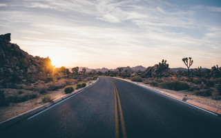 Mountain road sunset clouds city - a mountain in the background and a sky free wallpaper
