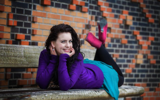 Woman bench urban brick blurry - a brick wall behind her free wallpaper