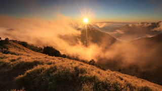 Sunrise mountain grassy hill people - over a mountain range free wallpaper
