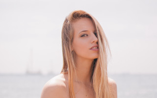 Blonde woman ocean sailboat sunny - a sailboat in the background free wallpaper