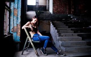 Woman sitting ruined building denim - behind her free wallpaper
