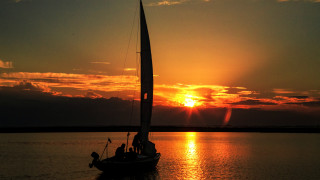 Sailboat sunset water clouds horizon - a sailboat free wallpaper
