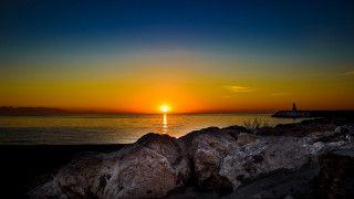 Sunset lighthouse rocks boat water - a lighthouse in the distance free wallpaper