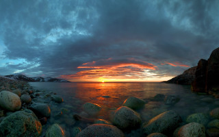 Sunset water rocks mountain beach - a sunset over a body of water free wallpaper