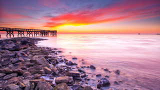 Sunset pier ocean rocks cityscape - a pier free wallpaper for desktop