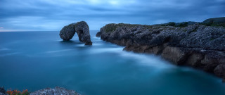 Long exposure rock formation ocean - a cloudy sky above free wallpaper