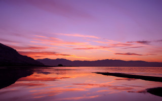 Sunset mountain water pink sky - a mountain in the background and a body of water free wallpaper
