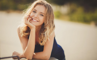 Woman smiling leaning on table - her chin free wallpaper