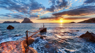 Sunset ocean boat rocky shore - a rope free wallpaper