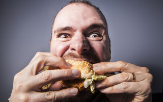 Man eating sandwich wide eyed - toothy free wallpaper