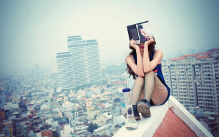 Rooftop cityscape woman reading iphone - tall building free wallpaper