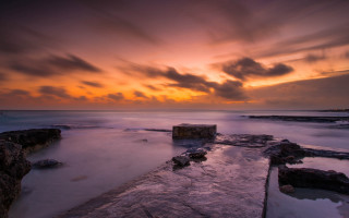 Sunset rocky beach jetty dusk - rich moody colour free wallpaper