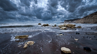 Stormy beach rocks water cloudy - a few cloud above free wallpaper