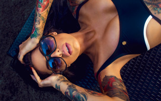 Tattooed woman laying sunglasses armor - a mat free wallpaper